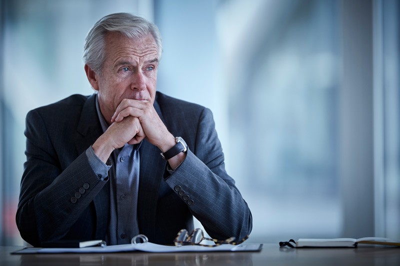 dirigeant d’entreprise en réflexion face à des décisions stratégiques importantes
