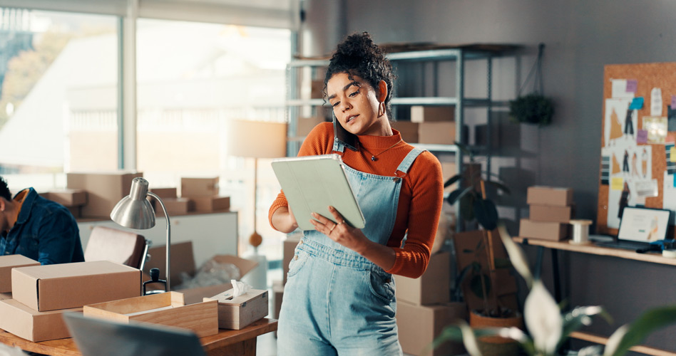 Dirigeante de petite entreprise gérant ses commandes et son activité avec tablette